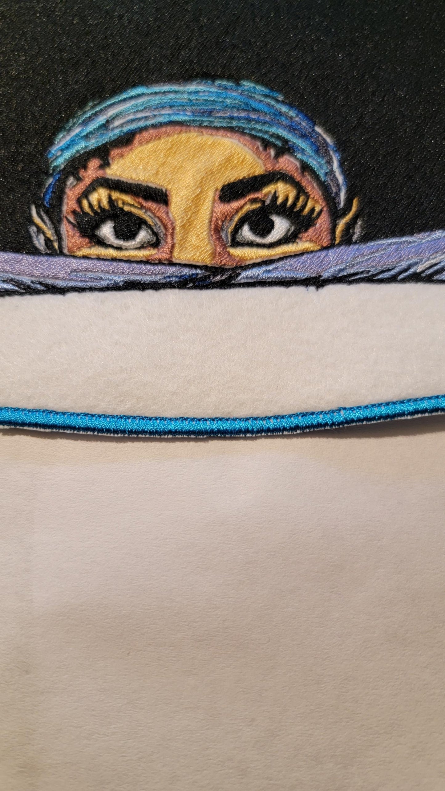 Playful Embroidered Patch features a whimsical young lady peeking over the top of her folded arms, ready for adventure!