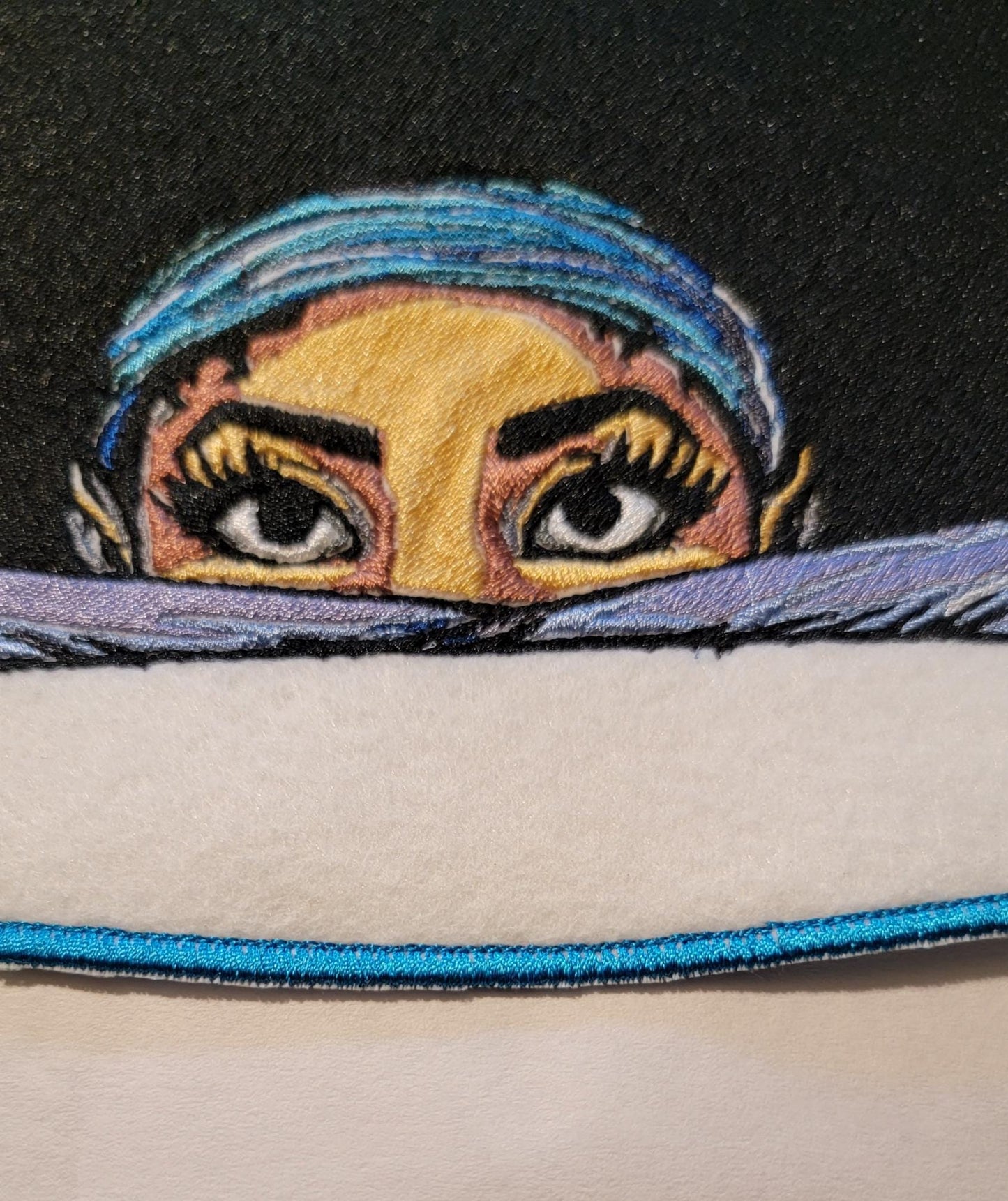 Playful Embroidered Patch features a whimsical young lady peeking over the top of her folded arms, ready for adventure!