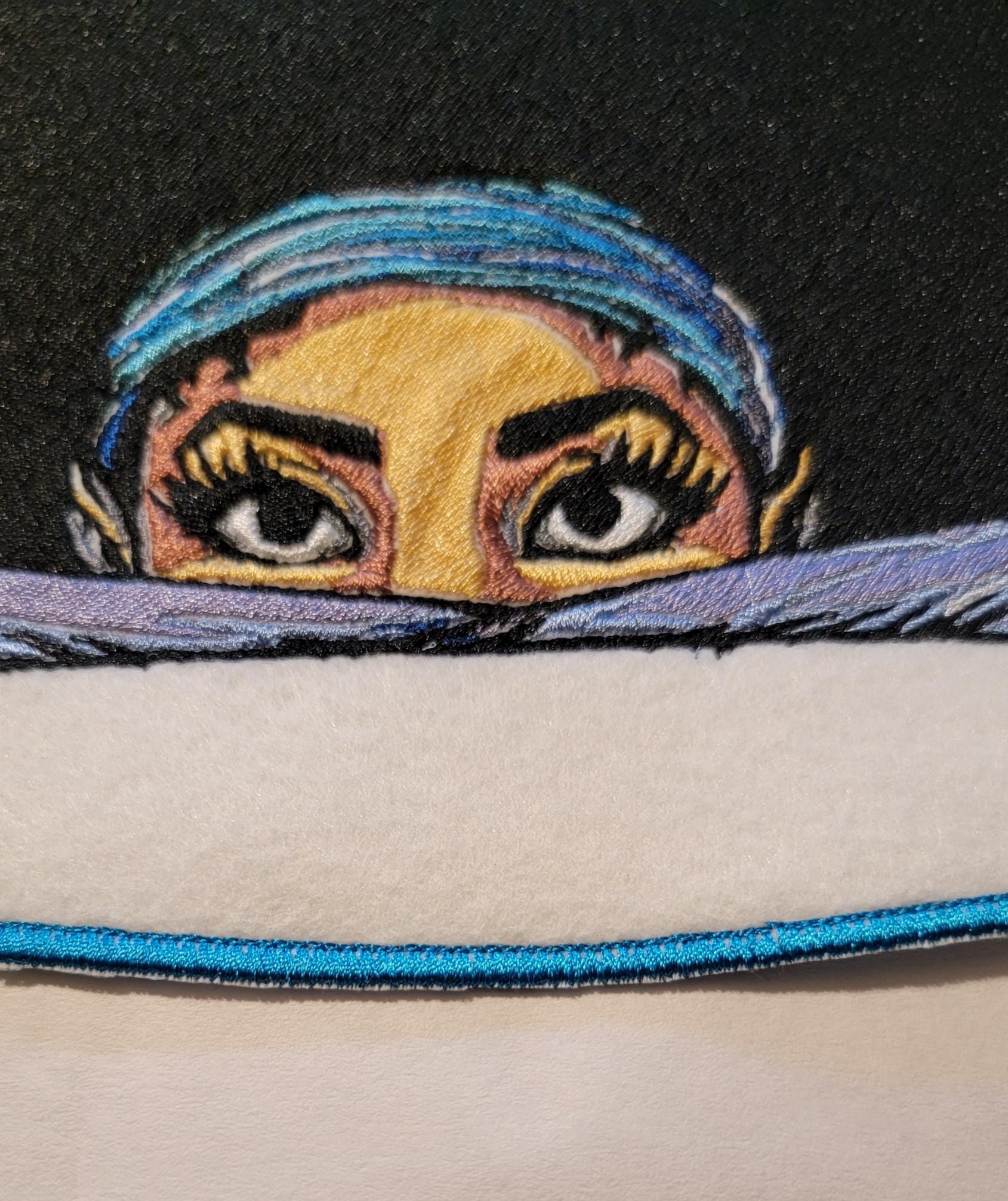 Playful Embroidered Patch features a whimsical young lady peeking over the top of her folded arms, ready for adventure!