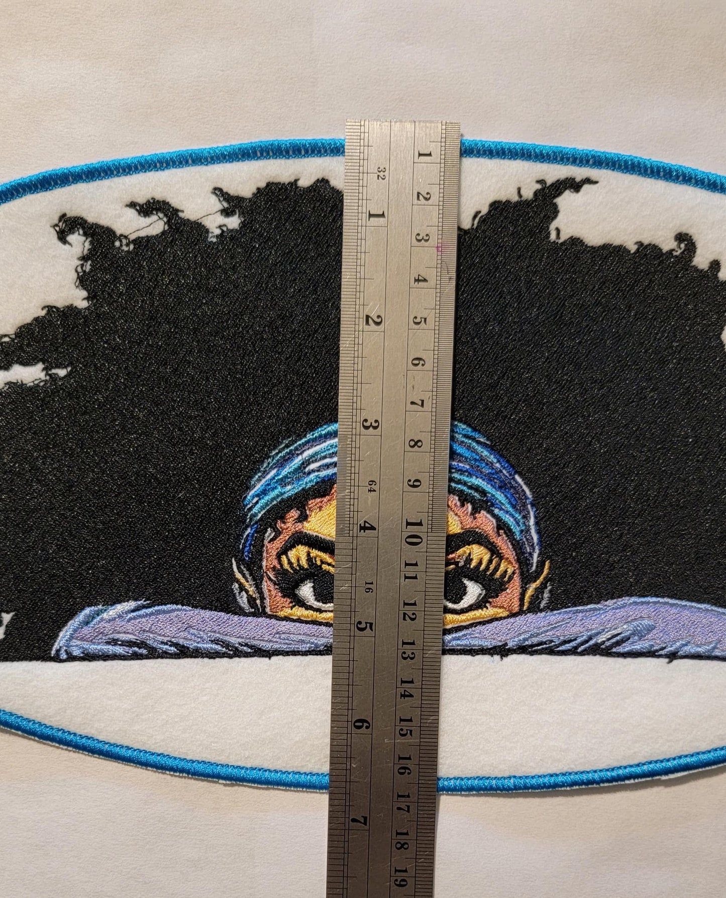 Playful Embroidered Patch features a whimsical young lady peeking over the top of her folded arms, ready for adventure!